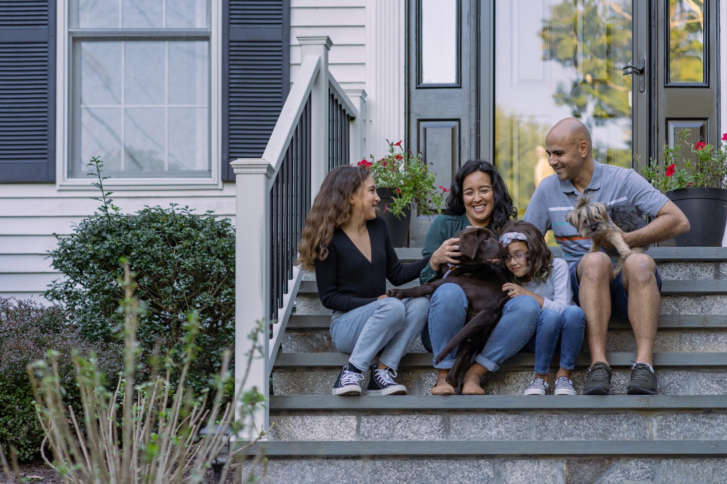 Happy family sitting outside on the front porch