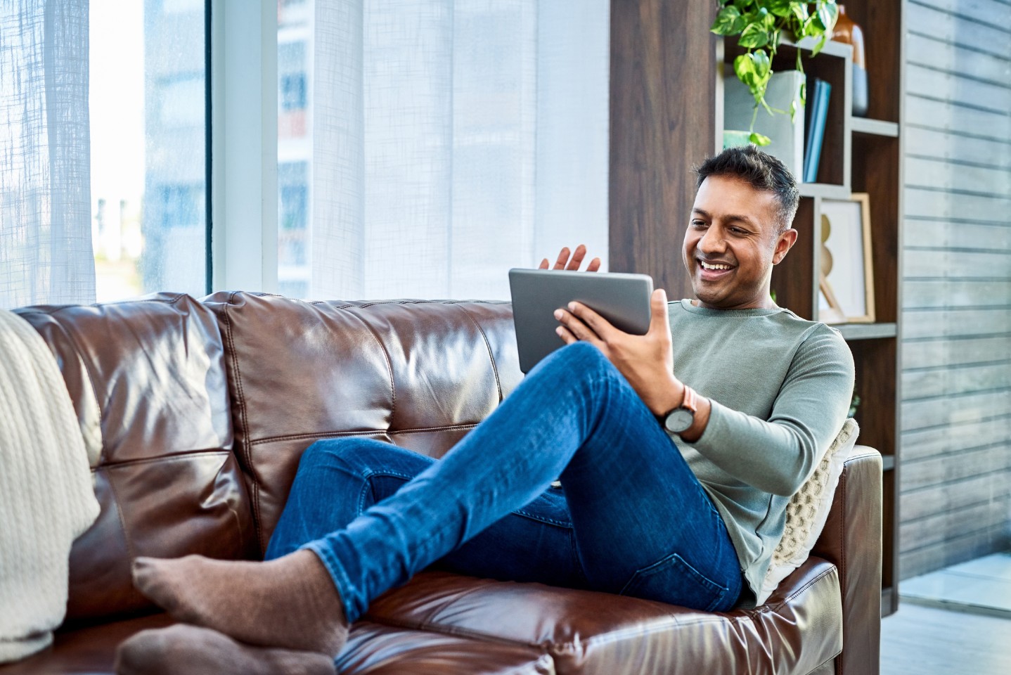 Man smiling and using a tablet