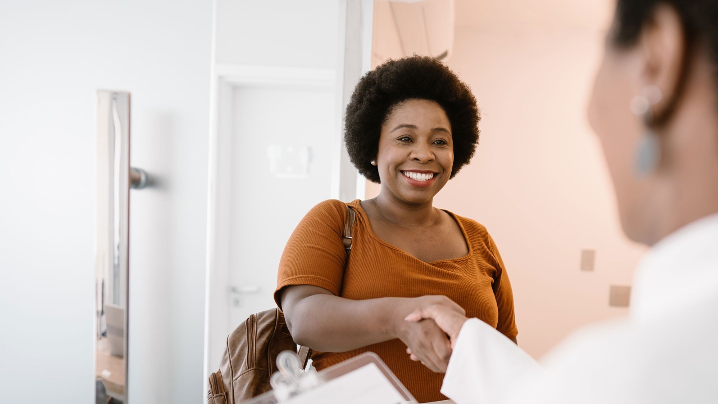 Smiling female patient meeting doctor